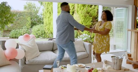 Joyful African American Couple Dancing in Home Celebration