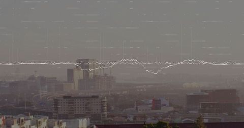 Framing skyline from rooftop showing midrise blocks, cranes and digital waveform overlay