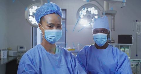 Surgical team preparing for operation in modern operating room wearing masks and scrubs