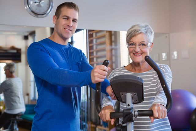 Physiotherapist assisting senior woman on exercise bike - Download Free Stock Photos Pikwizard.com