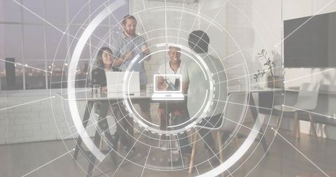 Collaborating startup team using laptop with futuristic hud overlay in modern office at dusk