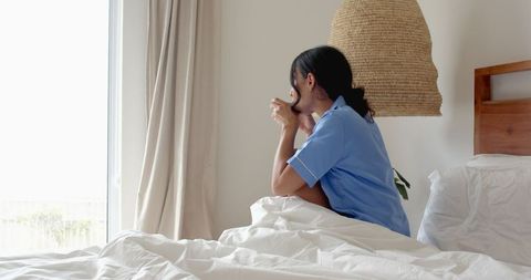 Nurse Relaxing with Morning Coffee by Bedroom Window