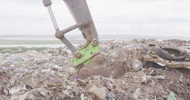 Close up of of landfill with piles of litter and excavator. Landfill, waste, pollution and environment.