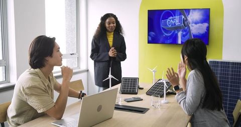 Diverse team discussing green energy solutions in modern office