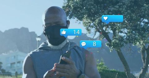 Man using smartphone wearing mask and earphones outdoors with social media reactions
