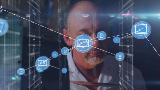 This visual innovation presents a senior male scientist immersed in analyzing technology and digital network connections. The imagery offers a cross-hatched screen layered with technology icons symbolizing connectivity and scientific advancement. Suitable for exploring themes of scientific research, technological growth, or communication networks in presentations or articles.