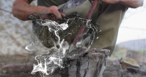 Artisan metalworking outdoors, man sharpening blade with skill