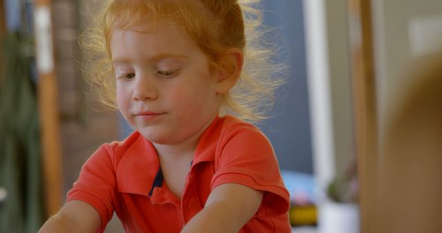 Red-Haired Child Concentrating Indoors - Download Free Stock Images Pikwizard.com