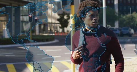 Young Man at Urban Crosswalk with World Map Overlay