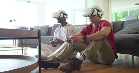 Diverse friends playing VR multiplayer games with wireless headsets and controllers at home
