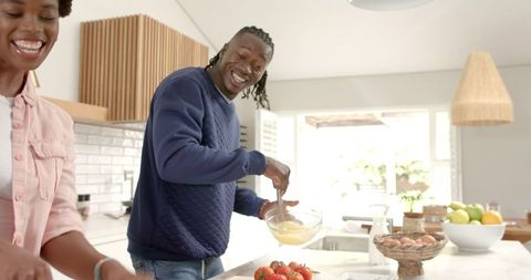Joyful African American Couple Preparing Meal in Modern Kitchen