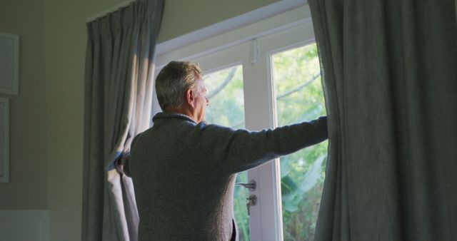 Senior Man Opening Curtains to Let in Morning Light - Download Free Stock Images Pikwizard.com