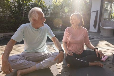 Senior Couple Practicing Yoga Outdoors on Wooden Deck