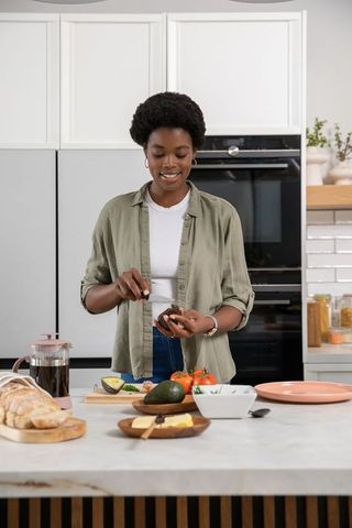Woman preparing avocado meal in modern kitchen