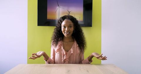 Businesswoman Presenting with Wind Turbine Display Background