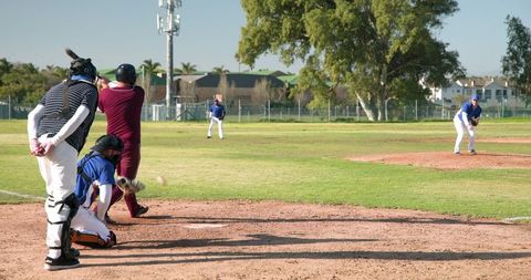 Baseball game action with batter swinging at pitch