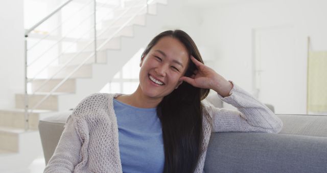 Smiling Woman Relaxing on Sofa in Living Room - Download Free Stock Images Pikwizard.com