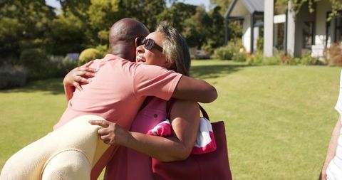 Joyful senior friends embracing in sunny park for friendship and togetherness