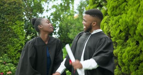 Joyful Graduates Celebrating Success Outdoors in Caps and Gowns