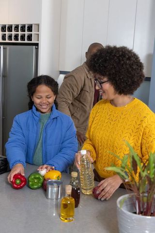 Family preparing healthy meal together in cozy modern kitchen with colorful vegetables