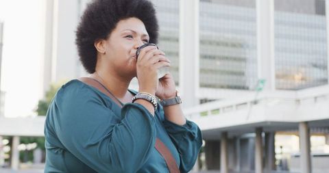 Happy Plus Size Woman Drinking Coffee and Using Smartphone Outdoors