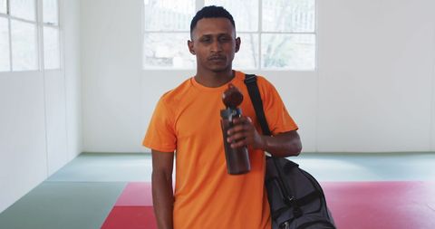 Confident Teenage Judo Athlete Refreshing After Training