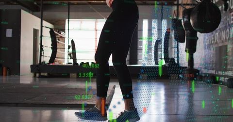 Female balancing on toes in gym with digital HUD overlay for fitness training