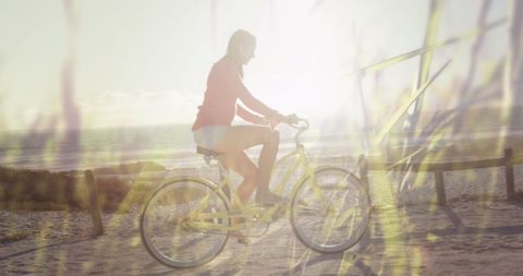 Joyful Woman Cycling on Beach Amidst Tall Grass - Download Free Stock Images Pikwizard.com