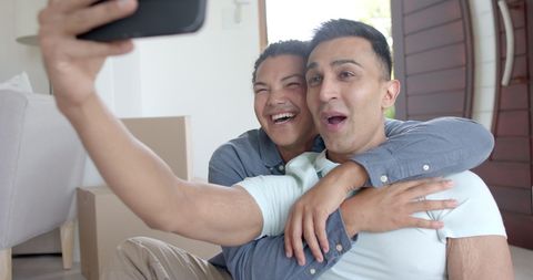Happy Gay Couple Taking Selfies During Move-In Day