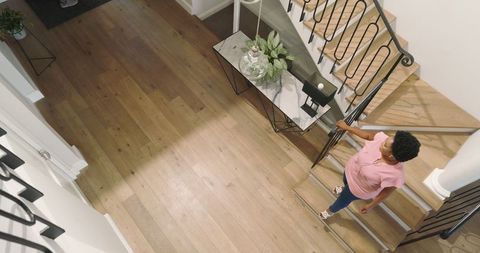 Woman Walking Downstairs in Modern, Spacious Home Interior