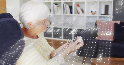 Senior woman checking blood glucose at home with digital meter and data overlay