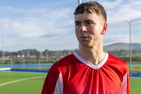 Young male athlete in red jersey on turf field