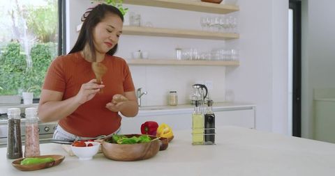 Woman prepares fresh salad in contemporary kitchen