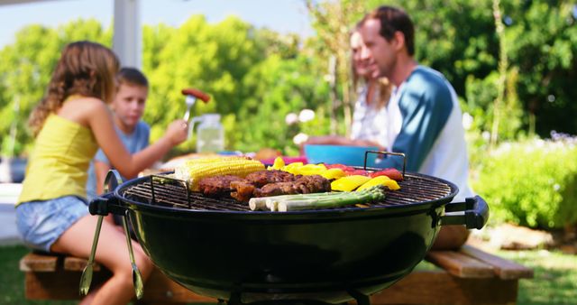 Family Enjoying Outdoor Barbecue on Sunny Day - Download Free Stock Images Pikwizard.com