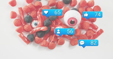 Halloween candy flatlay: red licorice, gummy berries and eyeball novelties with social bubbles