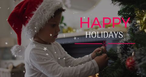 Young Child Decorating Christmas Tree with Santa Hat