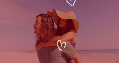 Couple Enjoys Playful Beach Day with Romantic Hearts