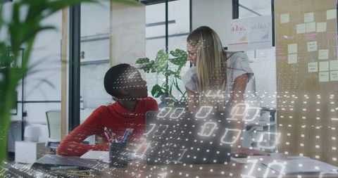Collaborating women discussing data-driven project in modern office with digital overlay