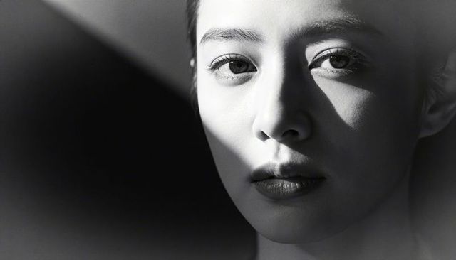 Woman facing split light monochrome portrait showing dramatic chiaroscuro shadow play