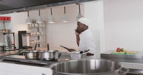 Professional Chef in Modern Kitchen Using Technology During Meal Prep