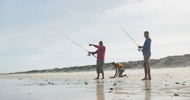 Three friends surf fishing on a coastal beach, enjoying outdoor activity together. Great for promoting outdoor leisure activities, travel destinations, friendship, or fishing gear advertisements.