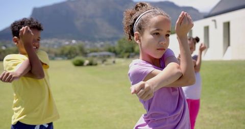 Children Practicing Outdoor Martial Arts in Scenic Field