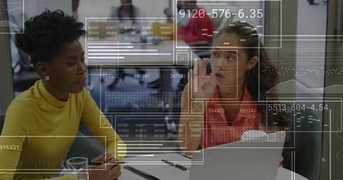 Two Professional Women Analyzing Data with a Laptop