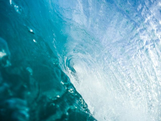 This image captures a closeup view of a majestic ocean wave with clear, turquoise water, illustrating the beauty and power of nature. Perfect for use in travel brochures, adventure and surf sports promotions, environmental campaigns, and ocean conservation materials.