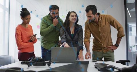 Engineering team examining drone prototype on table during collaborative design session