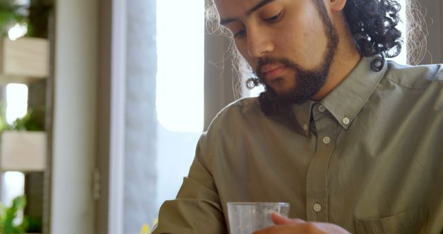 Man Reflecting While Holding Coffee Cup in Sunlit Room - Download Free Stock Images Pikwizard.com