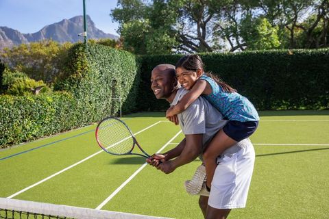 Father and Daughter Bonding During Fun Outdoor Tennis Adventure