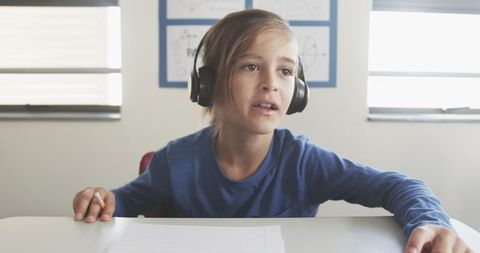 Young student concentrating with headphones in classroom