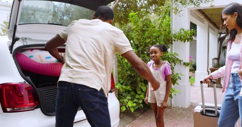 Diverse Family Packing Car for Summer Vacation with Inflatable Float