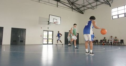Energetic Basketball Players Engaged on Indoor Court